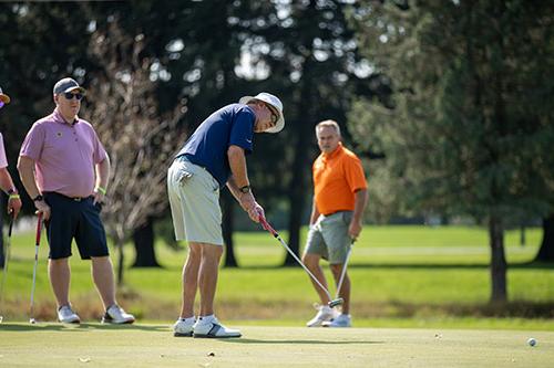 Men putting on golf course